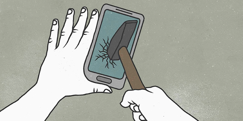 Imagen de una mano destrozando un teléfono móvil con un martillo